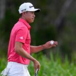 Collin Morikawa raccoglie la pallina dopo un'imbucata