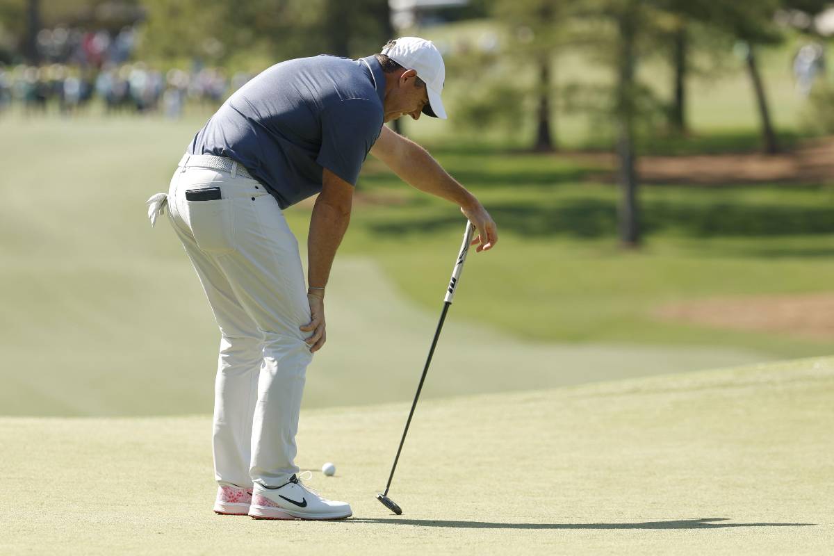Rory McIlroy piegato sulle ginocchia sul green